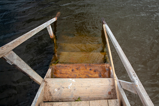an old wooden staircase on the pier, an old rotting wooden staircase leading to the lake