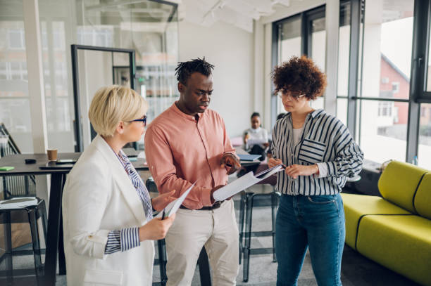 istock Multiracial business colleagues discussing about documents in the office 1401420350