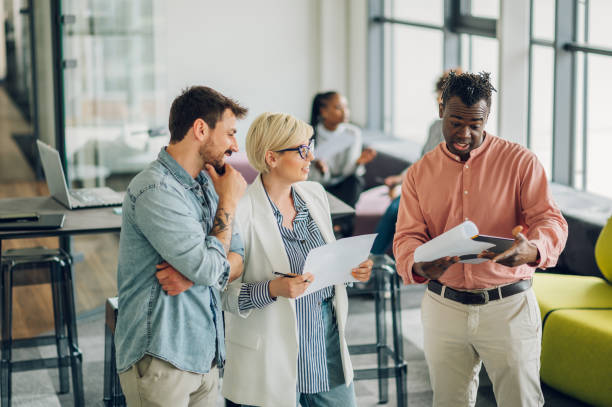 istock Multiracial business colleagues discussing about documents in the office 1401420353