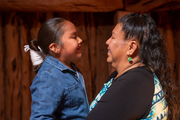 sweet interaction between a grandmother and her grandson,  smiling, talking and looking at each other, hugging - native american north american tribal culture women mature adult imagens e fotografias de stock