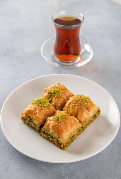 istock Pistachio baklava on a white plate with Turkish tea.A plate baklava on white background 1401422856