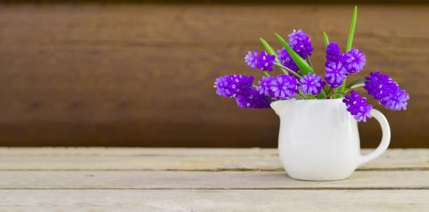istock Banner with a single small ceramic white vase-jar with fresh blooming purple-blue muscari flowers 1401426018