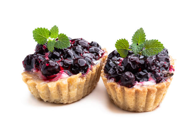 istock Shortcrust tartlets with cream cheese and black currant isolated on white 1401427011