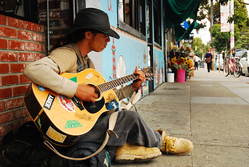 San Francisco, CA USA August 24 A young man plays guitar for money on the sidewalks of the Haight Ashbury district of San Francisco.
