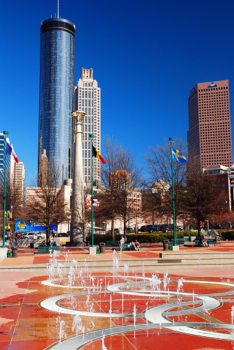 Atlanta, GA, USA March 1 Water fountains spray in Centennial Park, created for the 1996 Olympics and surrounded by the skyline of Atlanta