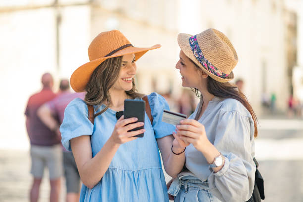 istock Cheerful travelers using a mobile phone to make a purchase during the vacation 1401430484