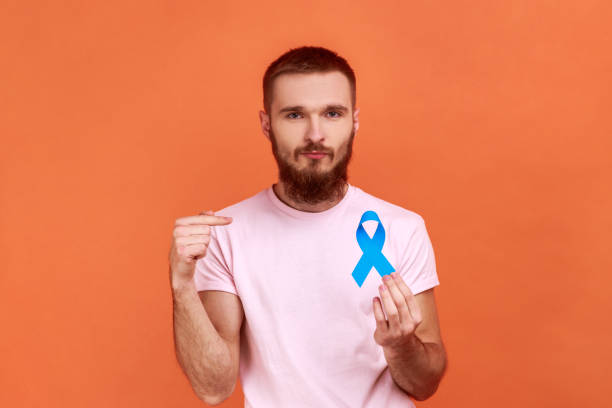 istock Man pointing finger at blue awareness, disease symbol, looking at camera, support. 1401432774