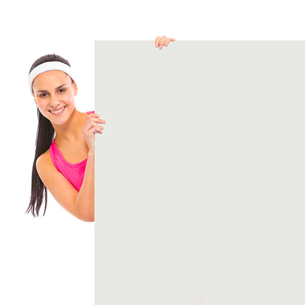 istock Smiling girl looking out from blank billboard isolated on white 140143576