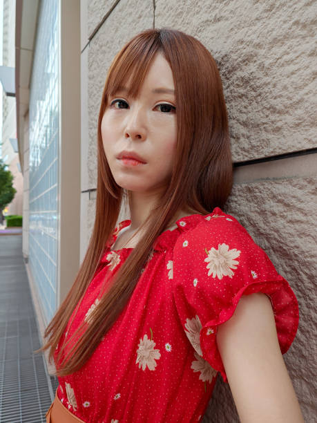 Young woman in red dress visiting city for live streaming as a job. Working as an influencer on multiple social media sites.
