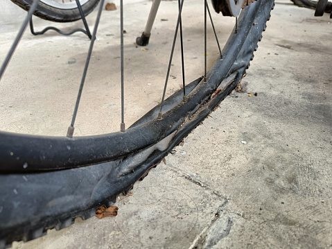 Flat old dusty bike tire on ground.