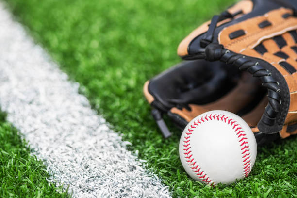 istock A new baseball and a glove sitting along the white baseline 1401444881