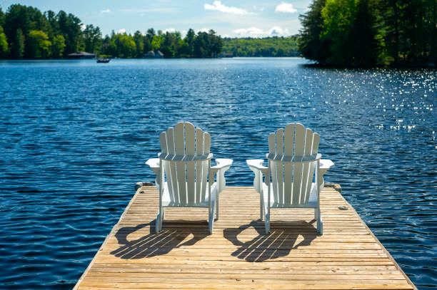 White Adirondack chairs on a sunny morning stock photo