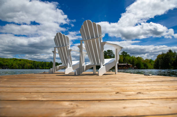 Side view of two white Adirondack chairs stock photo