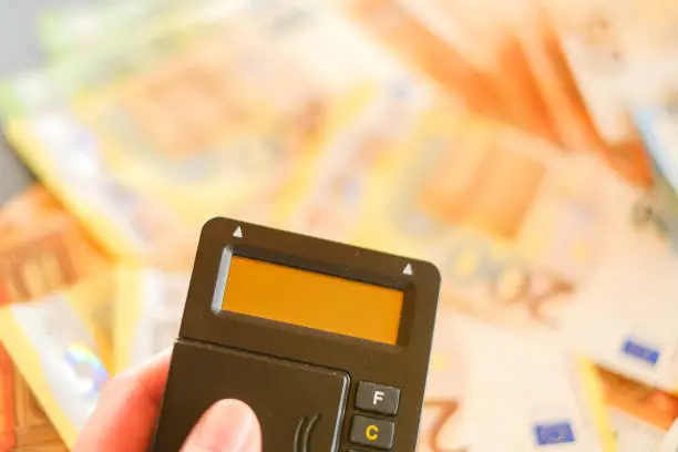 Money transfers. Paying bills online.Payment by bank card.bank plastic card into a card reader on euro bills background.