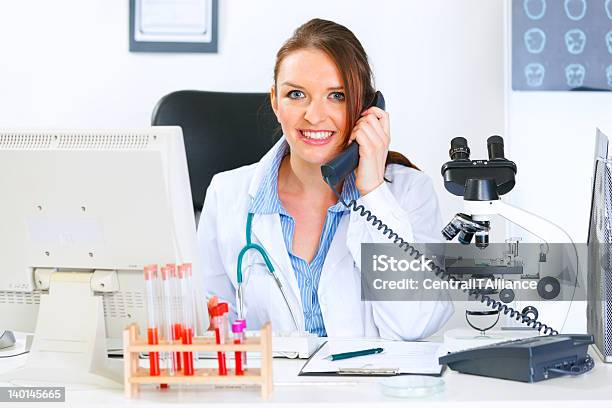 笑顔の女性医師シッティングエリアテーブル電話で話している - オフィスのストックフォトや画像を多数ご用意 - オフィス, オフィスチェア, コミュニケーション