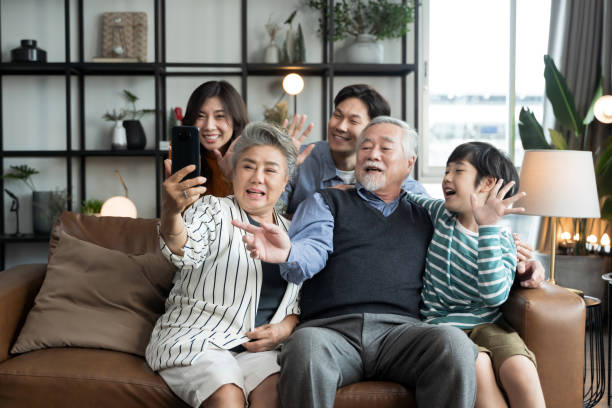 Asian big family taking selfie together at home. stock photo