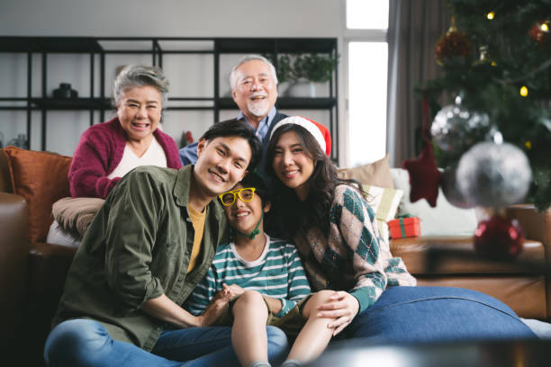 Portrait Asian family near Christmas tree together at home. family, generation, christmas and people concept stock photo