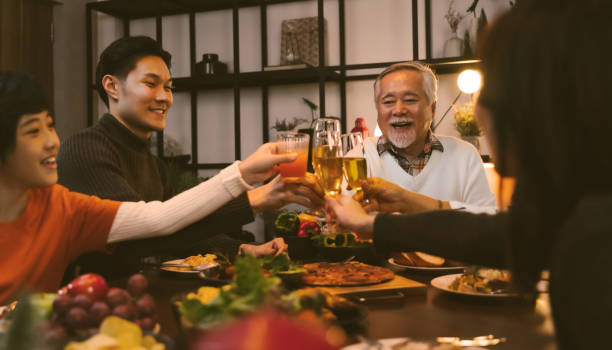 집에서 식탁에서 저녁 식사를 하는 아시아 가족 - champagne toast wine restaurant 뉴스 사진 이미지