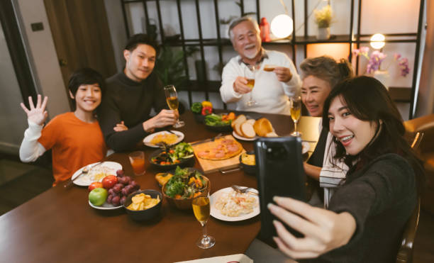 istock Asian family having taking selfie before dinner at dining table at home 1401456860