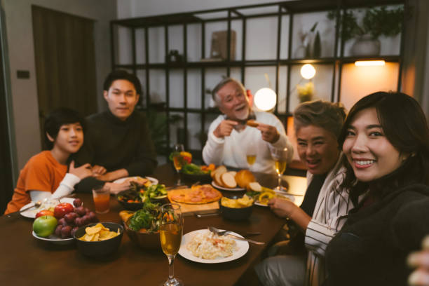 istock Asian family having taking selfie before dinner at dining table at home 1401456865