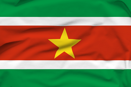 Suriname national flag, folds and hard shadows on the canvas.
