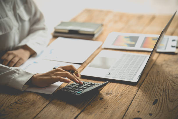 istock Accountant working on desk using calculator for calculate finance report in office. 1401458119
