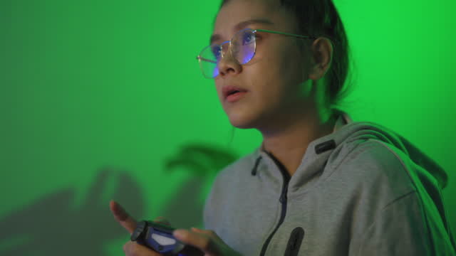 Young Asian Woman Focusing on Her Game while Trying to Win.