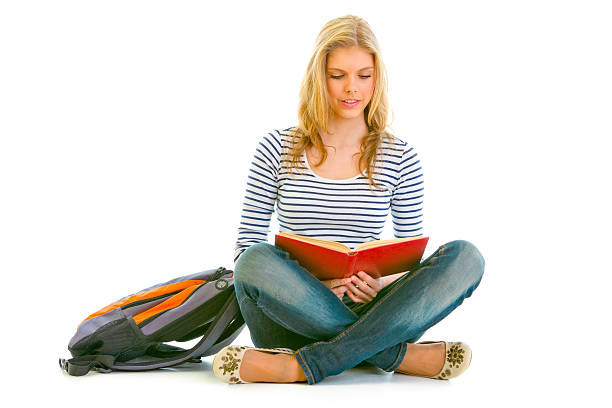 istock Pensive teengirl with schoolbag sitting on floor and reading book 140145895