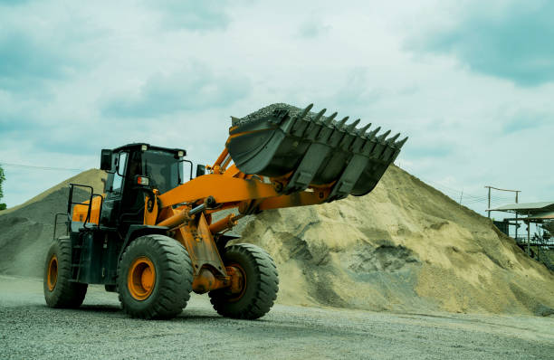 istock Sand loaders are shoveling rocks into dump trucks. 1401460276