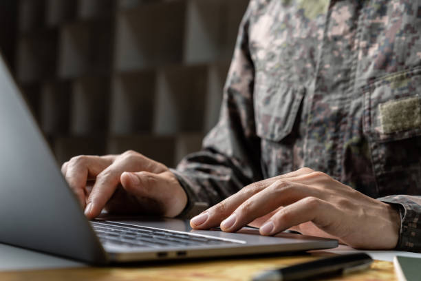 istock Soldier in camouflage uniform working on laptop for Information Operation. 1401460581
