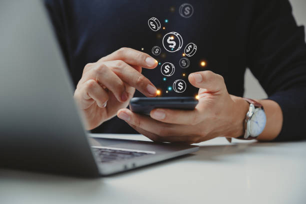 mano de hombre de negocios usando teléfono inteligente con icono de moneda. - pagar fotografías e imágenes de stock