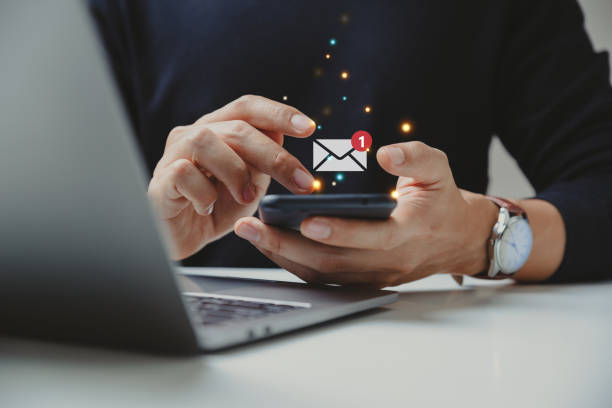 ręka biznesmena używającego smartfona do e-maila z powiadomieniem. - spam e mail marketing internet zdjęcia i obrazy z banku zdjęć