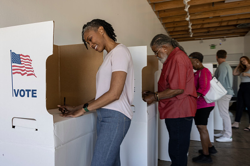A woman getting her voting ballot and going to vote.