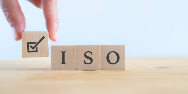 istock ISO standards quality control certification concept. Quality warranty and assurance.  Hand puts wooden cubes with check mark and ISO icons on white background and copy space. Modern ISO banner. 1401465232