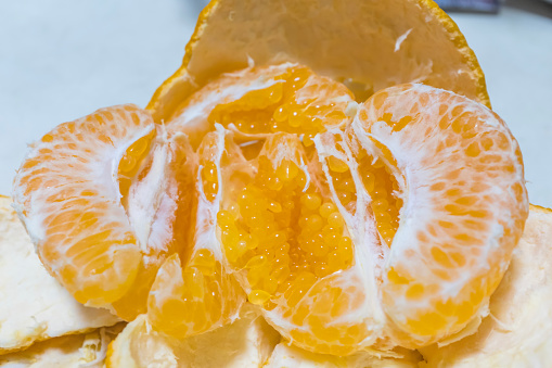 A ripe orange is peeled