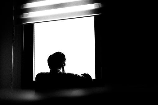 Window and silhouette of a person ,A person looking out the window