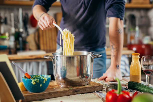istock handsome young man preparing food in his home kitchen 1401466901