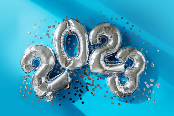 Silver numbers 2023 new year balloons in sunlight blue background stock photo
