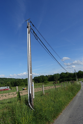 Outdoor fiber optic cable on concrete support pole  Countryside road  La Creuse France