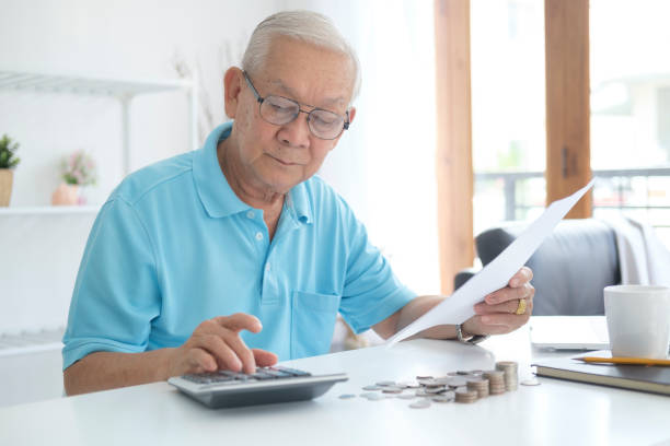 istock Serious man sitting at table near utility bill and calculating expenses 1401471839