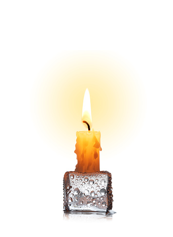 Candle glowing on ice cube isolated on a white background.