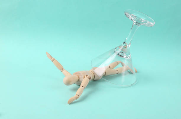 istock The puppet is covered with a cocktail glass on a blue background. Alcohol addiction 1401472822