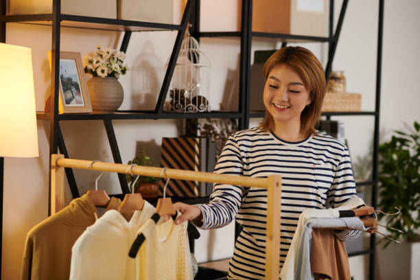 istock Woman Hanging Dresses on Rail 1401472979