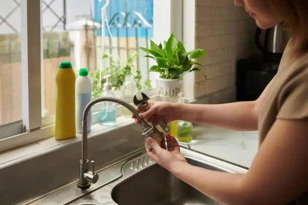 Photo of Woman Removing Kitchen Tap