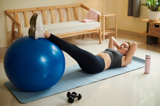 Woman Doing Crunches at Home stock photo