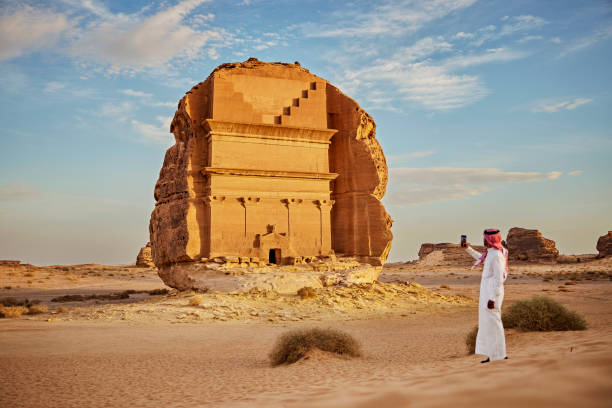 istock Local Saudi man photographing iconic rock-cut architecture 1401473290