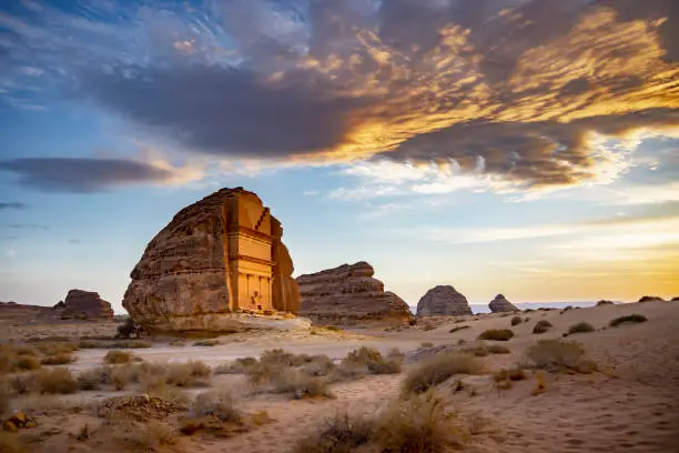 Full view under dramatic sky of iconic tomb also known as Qasr Al Farid, Saudi Arabia’s first UNESCO World Heritage Site erected in 1st-century CE.