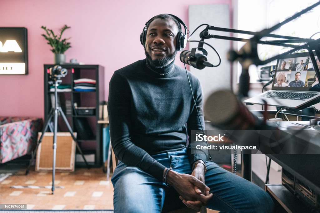Entrepreneur interviewed on a podcast Candid portrait of African-American entrepreneur interviewed on a radio podcast. Podcasting Stock Photo