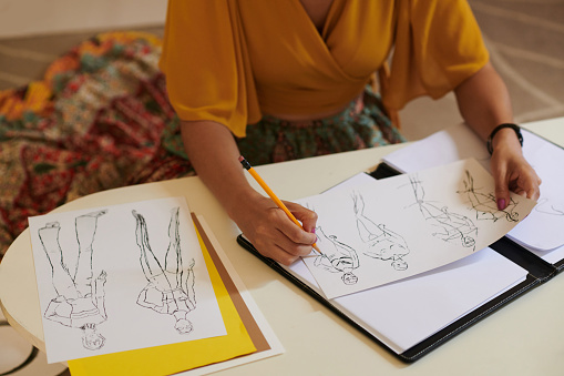 Close-up image of fashion designer drawing sketches for new collection