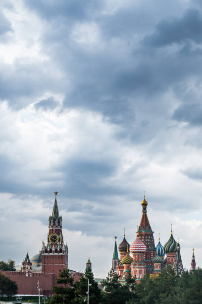 Close-up of the golden domes of a church with crosses on top, set against a dramatic stormy sky. The contrast highlights the bright gold and intricate details of the domes.